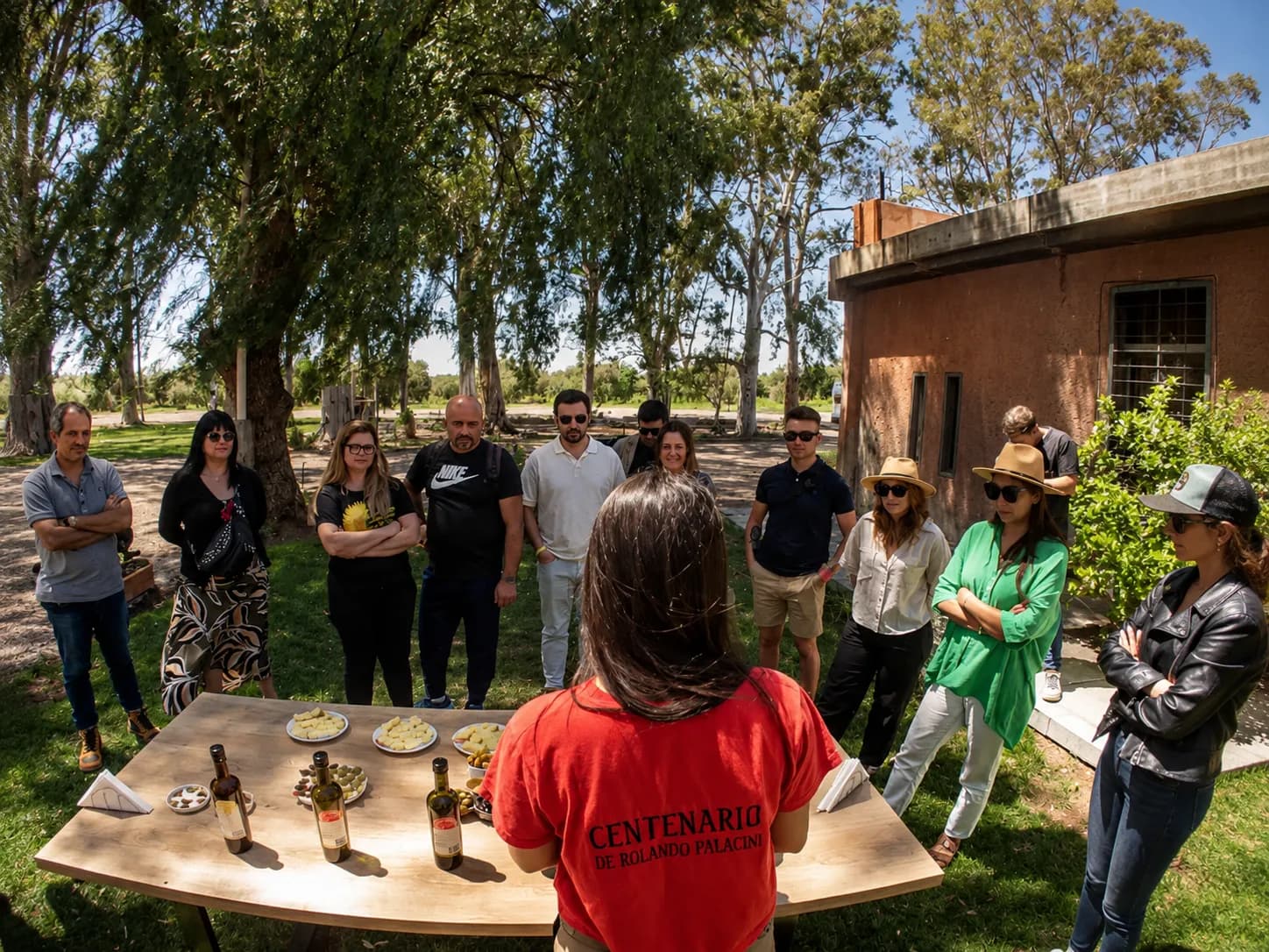 Copa de vino malbec sobre barrica en una bodega de Mendoza con viñedos al fondo